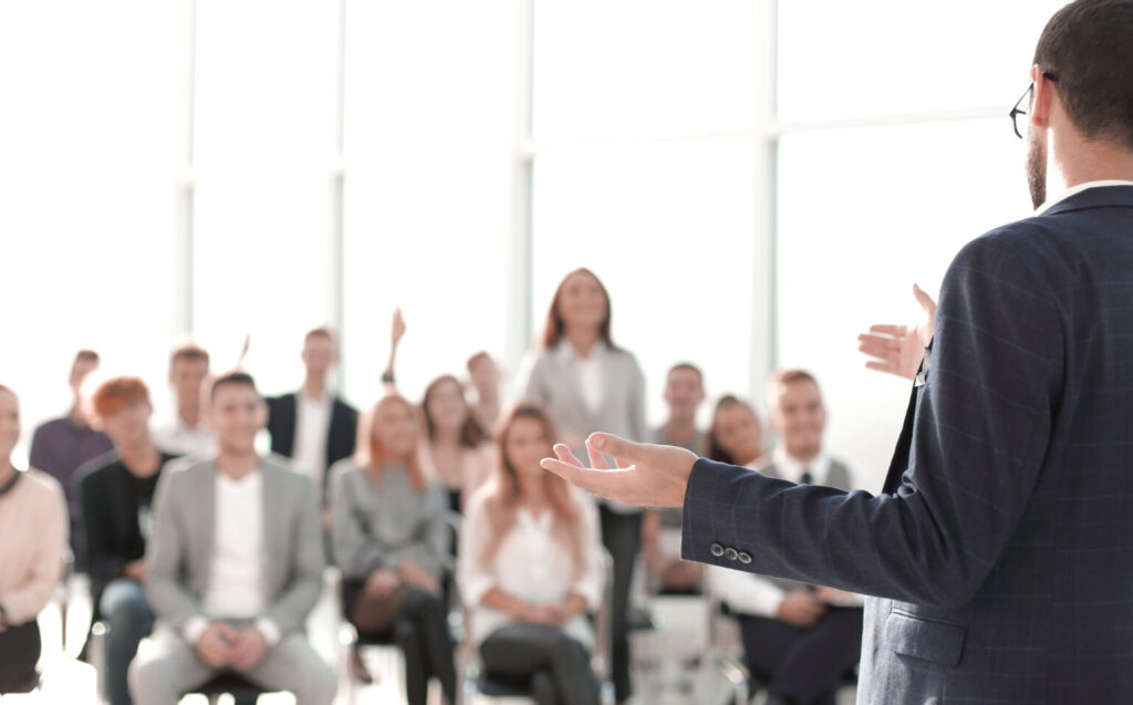 close up speaker standing front audience conference room 1536x956 1